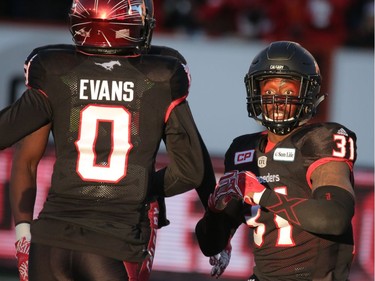 Calgary Stampeders Brandon McDonald reacts with Ciante Evans after diving into the end zone for a touchdown after an interception against the BC Lions in Western Final CFL action at McMahon Stadium in Calgary, Alta.. on Sunday November 20, 2016. Mike Drew/Postmedia