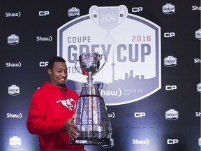 Calgary Stampeders defensive back Tommie Campbell picks up the Grey Cup ahead of the 104th CFL championship in Toronto.