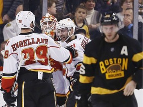 Calgary Flames' Chad Johnson, second from left, celebrates with teammates Deryk Engelland (29) and Mark Giordano (5) as Boston Bruins' David Krejci, right, of the Czech Republic, skates away after the Flames defeated the Bruins 2-1 during an NHL hockey game in Boston, Friday, Nov. 25, 2016.
