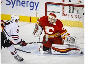 Chicago Blackhawks' Ryan Hartman, left, scores on Calgary Flames goalie Chad Johnson during first period NHL hockey action in Calgary, Friday, Nov. 18, 2016.