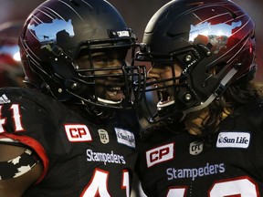 Calgary Stampeders' Cordarro Law (L) reacts with Alex Singleton after sacking B.C. Lions' quarterback Jonathon Jennings during fourth quarter CFL Western Final football action in Calgary, Sunday, Nov. 20, 2016.THE CANADIAN PRESS/Todd Korol ORG XMIT: TAK111