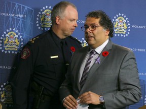 Calgary Police Chief Roger Chaffin (L) and Mayor Naheed Nenshi pass while speaking at a news conference on bullying and harassment in police ranks on Tuesday November 1, 2016 at Calgary Police Headquarters.