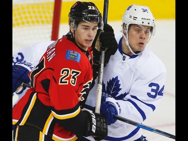 Calgary Flames centre Sean Monahan battles centre Auston Matthews of the Toronto Maple Leafs during NHL action in Calgary on Nov. 30, 2016.