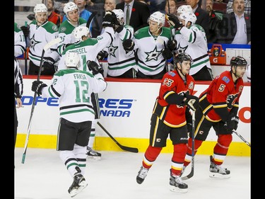 The Dallas Stars celebrate an empty-net insurance goal as Sean Monahan and Mark Giordano of the Calgary Flames skate by during NHL action in Calgary, Alta., on Thursday, Nov. 10, 2016. The Stars won 4-2.
