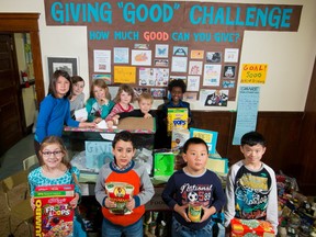 Students at Hillhurst  School stand with their school's Giving Good Campaign display as well as food that was collected for the Veterans Food Bank.