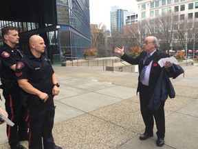 Former Calgary mayoral candidate Larry Heather is escorted off city hall property by city police on Monday, Nov. 7, 2016. He was issued a two-year ban from the municipal complex after a bitter back and forth in council chambers with Mayor Naheed Nenshi. Shawn Logan/Postmedia