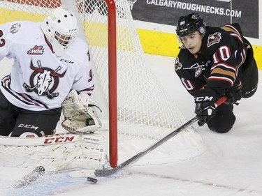 Jakob Stukel of the Calgary Hitmen tries an unsuccessful wrap-around on Red Deer Rebels goalie Riley Lamb at the Scotiabank Saddledome in Calgary on Nov. 22, 2016.