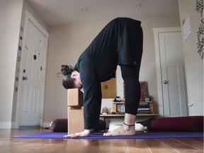 Jo Steinfeld demonstrates the Uttanasana (standing forward fold with head support) yoga pose for Steinfeld's November 2016 yoga column. (Kerianne Sproule/Postmedia)
