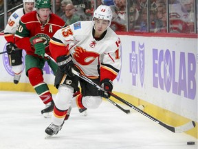 Calgary Flames left wing Johnny Gaudreau (13) controls the puck as he is pursued by Minnesota Wild defenseman Ryan Suter (20) during the second period of an NHL hockey game, Tuesday, Nov. 15, 2016, in St. Paul, Minn. Gaudreau had the only goal of the night as Calgary won 1-0.