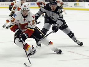 Calgary Flames left wing Johnny Gaudreau (13) controls the puck against Los Angeles Kings center Tyler Toffoli (73) during the third period of an NHL hockey game in Los Angeles, Saturday, Nov. 5, 2016. The Kings won 5-0.