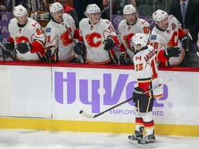 Calgary Flames left wing Johnny Gaudreau (13) is congratulated by teammates after he scored on a power play against the Minnesota Wild during the first period of an NHL hockey game, Tuesday, Nov. 15, 2016, in St. Paul, Minn.