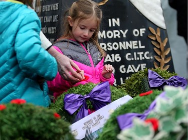 Julia Hebert, 4, places her poppy on a wreath  during the Remembrance Day ceremony at the Military Museums in Calgary, Alta., on Friday November 11, 2016.