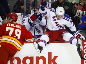 The New York Rangers' Kevin Hayes is checked into the bench by the Calgary Flames' Michael Ferland on Saturday. Reader is disappointed that Calgary fans booed their team for the 4-1 loss.
