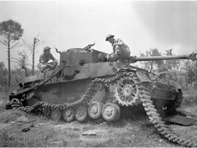 Members of the Royal Canadian Artillery examine a knocked out German Mark IV tank in 1944.