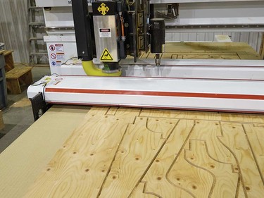 An overhead router cuts frame pieces.