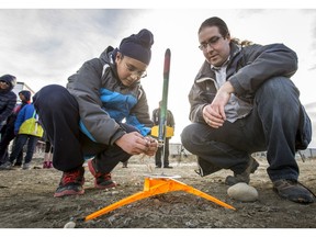 Sumair Shergill, age 13, Grade 8, is helped with his model rocket by Kevin Cammack at Renert School in Calgary, Alta., on Wednesday, Nov. 30, 2016. Fifty students from Grades 4 to 9 began studying science and rocketry in September under coordination from the University of Calgary's Department of Physics and Astronomy, Faculty of Science. They recently built their own rockets and test-launched them today in preparation for a spring festival. Lyle Aspinall/Postmedia Network