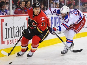 Mikael Backlund #11 of the Calgary Flames skates with the puck past Keith Yandle #93 of the New York Rangers during an NHL game at Scotiabank Saddledome on December 12, 2015 in Calgary, Alberta, Canada.
