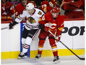 Chicago Blackhawks' Patrick Kane, left, gets past Calgary Flames' Sam Bennett during second period NHL hockey action in Calgary, Friday, Nov. 18, 2016.