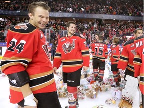 Calgary Hitmen Carsen Twarynski, left and Tyler Mrkonjic laugh as they watch thousands of stuffies fly on to the ice in the annual Teddy Bear Toss game on Saturday November 26, 2016. The Hitmen were taking on the Lethbridge Hurricanes in the game and Micheal Zipp scored the Hitmen's first goal to trigger the avalanche of teddies.