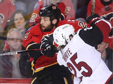 Deryk Engelland of the Calgary Flames hits Ryan White of the Arizona Coyotes at the boards during the first period at the Saddledome Wednesday November 16, 2016.