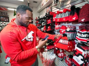Calgary Stampeders running back Jerome Messam video chats with his girlfriend as he shops for a Stampeders toque for her in the Stamps Store at McMahon Stadium on Monday November 21, 2016. The Stamps are heading to Toronto tomorrow ahead of the Grey Cup next weekend. GAVIN YOUNG/POSTMEDIA