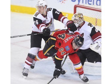 Garnet Hathaway of the Calgary Flames is cross checked by Michael Stone of the Arizona Coyotes in front of the Arizona net in the second period at the Saddledome Wednesday November 16, 2016.