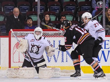 Mark Kastelic #12 of the Calgary Hitmen looks for an opening in front of the net of Riley Lamb #33 of the Red Deer Rebels during a WHL game at Scotiabank Saddledome on November 22, 2016 in Calgary.