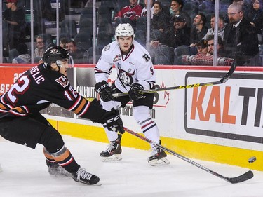 Mark Kastelic #12 of the Calgary Hitmen chases the puck against Josh Mahura #5 of the Red Deer Rebels during a WHL game at Scotiabank Saddledome on November 22, 2016 in Calgary.