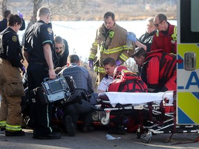 A man is readied for transport in an ambulance by EMS and fire personell after being pulled from the Bow River north of Carburn Park Monday November 21, 2016. He appeared to have been fishing in the river.