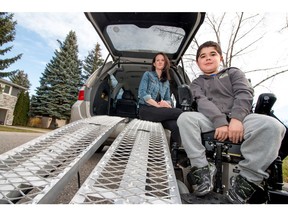 Sarah Groenewoud with makeshift ramps that her son Connor, 12, uses to roll his motorized wheelchair into their back of the van at their home in Calgary.