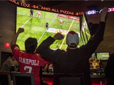 Crystal Schick/ Independent CALGARY, AB -- Maurice Lee, left, and Luke Hume, cheer for the Stampeders while watching the Western Conference Finals at Shark Club sports bar grill in Deerfoot Meadows in Calgary, on November 20, 2016. --  (Crystal Schick/Independent)
