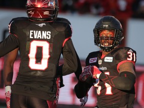 Calgary Stampeders Brandon McDonald reacts with Ciante Evans after diving into the end zone for a touchdown after an interception against the BC Lions in Western Final CFL action at McMahon Stadium in Calgary, Alta.. on Sunday November 20, 2016. Mike Drew/Postmedia
