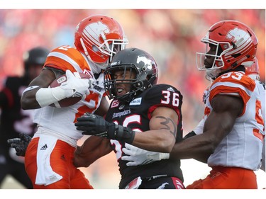 Calgary Stampeders  Glenn Love, middle, blocks BC Lions Chris Rainey. left, during CFL Western Final action at McMahon Stadium in Calgary, Alta.. on Sunday November 20, 2016. Leah hennel/Postmedia