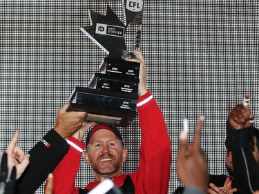 Calgary Stampeders head coach Dave Dickenson celebrates with the CFL's West Division Trophy after beating the BC Lions in the 2016 CFL West Final at McMahon Stadium in Calgary, Alta., on Sunday, November 20, 2016. AL CHAREST/POSTMEDIA