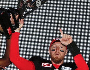 Calgary Stampeders Bo Levi Mitchell celebrates with the CFL's West Division Trophy after beating the BC Lions in the 2016 CFL West Final at McMahon Stadium in Calgary, Alta., on Sunday, November 20, 2016. AL CHAREST/POSTMEDIA