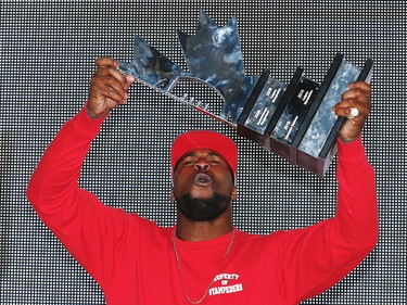 Calgary Stampeders Jerome Messam celebrates with the CFL's West Division Trophy after beating the BC Lions in the 2016 CFL West Final at McMahon Stadium in Calgary, Alta., on Sunday, November 20, 2016. AL CHAREST/POSTMEDIA