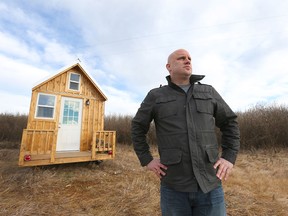 Gregg Taylor poses in front of his "tiny house" on the western edge of Calgary on Sunday, Nov. 20, 2016. Taylor rents the land the hand-built house sits on and he's having a battle with authorities who say he can't have the house on the property.