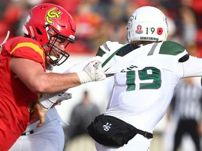 UC Dinos Brett Wade (L) grabs  University of Saskatchewan Huskies QB Kyle Siemens and records a sack during CIS action in Calgary, Alta on Saturday November 7, 2015. Jim Wells/Calgary Sun/Postmedia Network