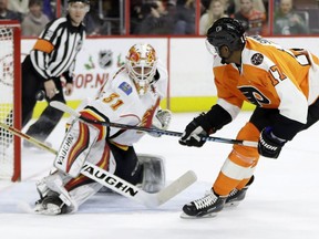 Philadelphia Flyers' Wayne Simmonds, right, scores a goal past Calgary Flames' Chad Johnson during the second period of an NHL hockey game, Sunday, Nov. 27, 2016, in Philadelphia.