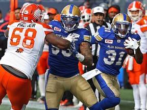 Winnipeg Blue Bombers DB Maurice Leggett (right) gets a block as he returns an interception against the B.C. Lions during CFL action in Winnipeg on Sat., Oct. 8, 2016. Kevin King/Winnipeg Sun/Postmedia Network ORG XMIT: POS1610081723271100