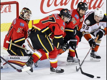 The Calgary Flames' Michael Frolik and Deryk Engelland work to clear the puck from the Anaheim Ducks' Jakob Silfverberg in front of goaltender Chad Johnson during NHL action at the Scotiabank Saddledome in Calgary on Thursday December 29, 2016.