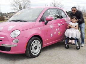 Julia Khaled sits for a photo with auto dealer Rachid El Madawi next to a pink Fiat 500 in Calgary, Alta. Khaled, a refugee from Lebanon shunned by her father due to her disability, is getting a break. Madawi, who owns Rachid's Auto Sales, restored a Fiat 500 in her favourite colour, to be auctioned off to finance risky surgery in the U.S. that is hoped will allow her to walk.Supplied photo