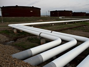 Pipelines run toward oil storage tanks stand at the Enbridge Inc. Cushing storage terminal in Cushing, Oklahoma, U.S., on Wednesday, March 25, 2015. A supply glut has dragged U.S. crude for May delivery almost $10 a barrel below contracts a year out. This market structure, known as contango, has encouraged traders to shove the most oil in 80 years into storage so they can sell it for more in the future. TradersÕ attempts to use every cubic inch of storage underscores how desperate the market has become to stow oil. Supplies at Cushing reached a record 54.4 million barrels as of March 13, Energy Information Administration data show. Nationwide, stockpiles at 458.5 million are the highest since 1930. Photographer: Daniel Acker/Bloomberg