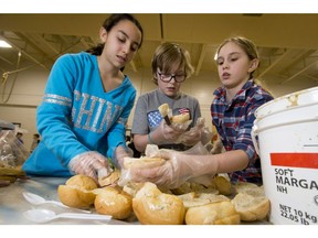 Ten-year-olds Maria Swaita, Justin Caouette and Poet Rowley make sandwiches at Holy Name School in Calgary, Alta., on Wednesday, Dec. 14, 2016. The children were working with the Sandwich Foundation to make 6,000 sandwiches for the Drop-In Centre.