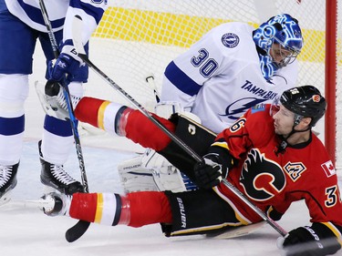 The Calgary Flames' Troy Brouwer collides with Tampa Bay Lightning goaltender Ben Bishop during NHL action at the Scotiabank Saddledome on Wednesday December 14, 2016.
