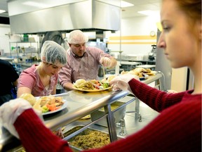 Laura Brager takes plates to tables. Hundreds of stomachs were filled at the Calgary Drop-In and Rehabilitation Centre downtown on December 25 as volunteers came together to provide a Christmas turkey dinner to anyone in need of a hot meal. RYAN MCLEOD/POST MEDIA CALGARY