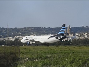 An Afriqiyah Airways plane from Libya stands on the tarmac at Malta's Luqa International airport, Friday, Dec. 23, 2016. Malta's state television says two hijackers who diverted a Libyan commercial plane to the Mediterranean island nation have threatened to blow it up.