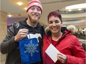 Calgary Stampeders quarterback Bo Levi Mitchell collects a gift card and gift from Connie Fekete, a Stamp's fan and supporter of Mitchell's Miracle Day, at Chinook Mall in Calgary, on December 12, 2016.