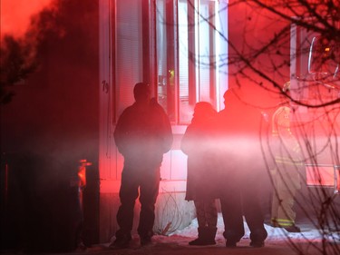 Neighbours watch as Calgary firefighters extinguish a fire in a mobile home at the Midfield Mobile Home Park on Wednesday evening December 7, 2016.