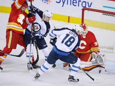 The Calgary Flames goaltender Chad Johnson stops this scoring chance by Winnipeg Jets forward Bryan Little during NHL action at the Scotiabank Saddledome in Calgary on Saturday December 10, 2016.